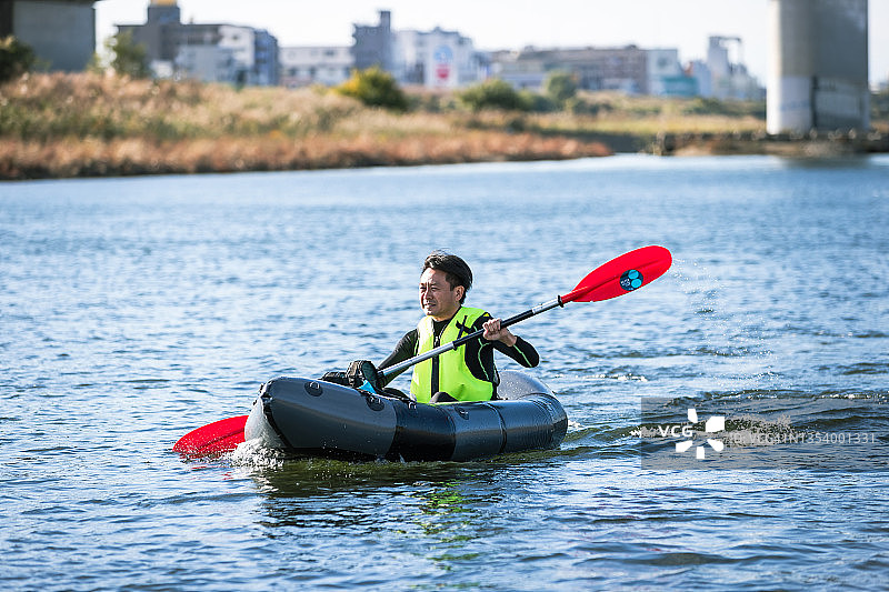 一群成年人在城市河流上享受划独木舟和桨板运动图片素材