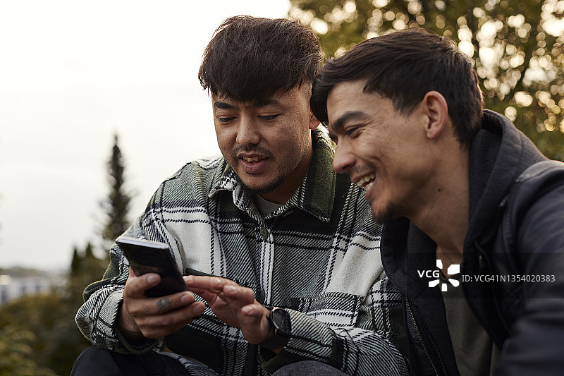 在户外使用智能手机的年轻男人图片素材