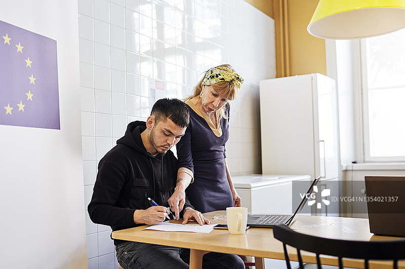在职业介绍中心，女子帮助年轻男子图片素材