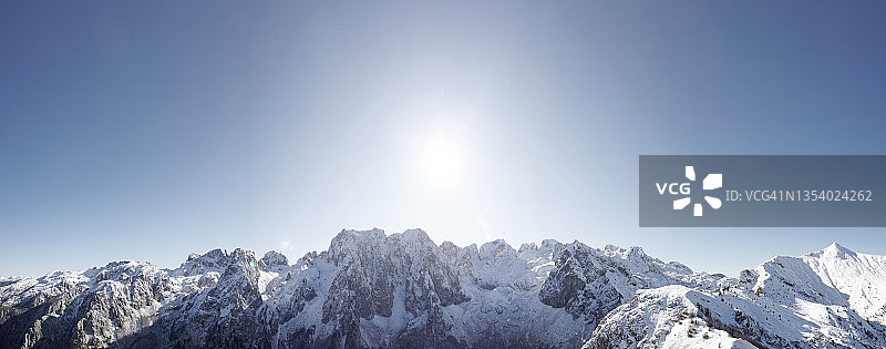 阳光明媚的雪山山脉全景图片素材
