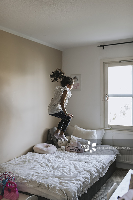 女孩在床上跳跃图片素材