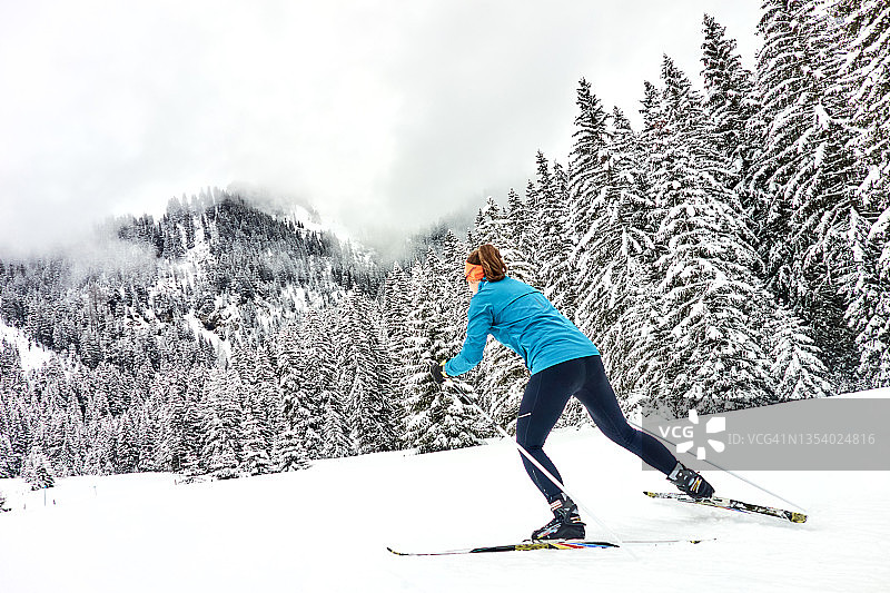 女子滑雪者沿着赛道走向森林图片素材