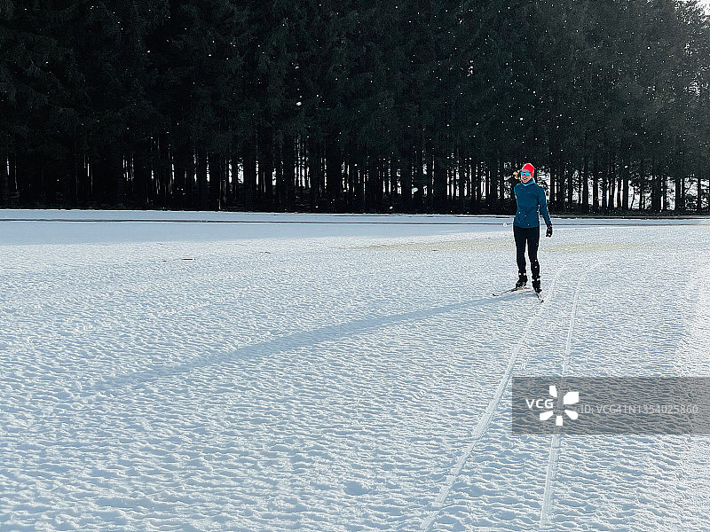 沿着森林滑雪道滑雪的女人图片素材