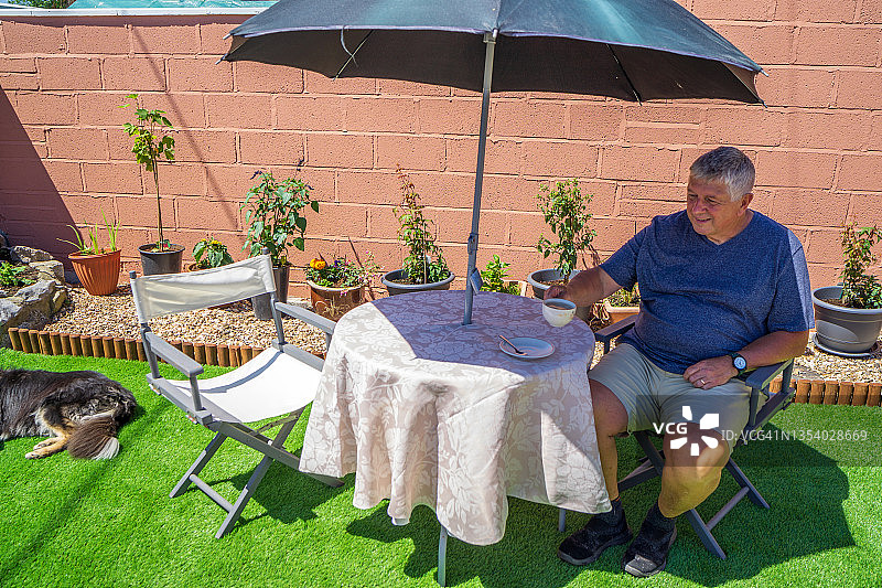 年长的男人在草坪上喝茶图片素材