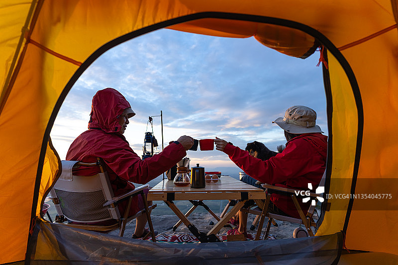 情侣在帐篷前享受早晨咖啡图片素材