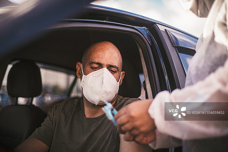 男人在汽车穿梭餐厅接种疫苗，预防新冠肺炎图片素材