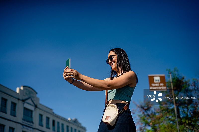 年轻女人在市中心使用智能手机图片素材