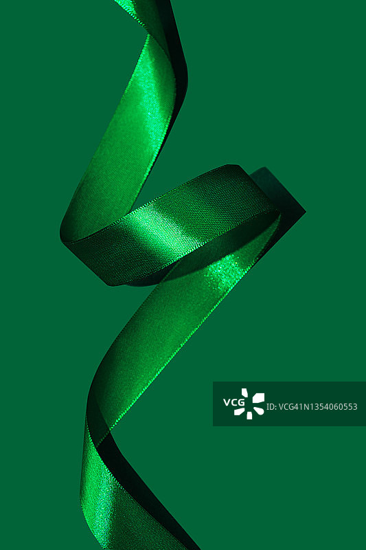 由2022年罗勒绿或淡绿色时尚卷曲粉色缎带制成的节日背景图片素材