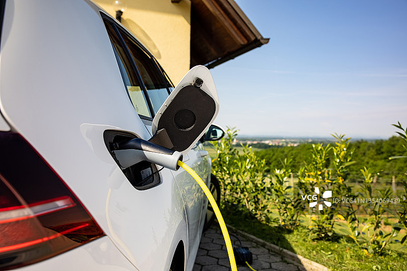 在家为电动汽车充电图片素材