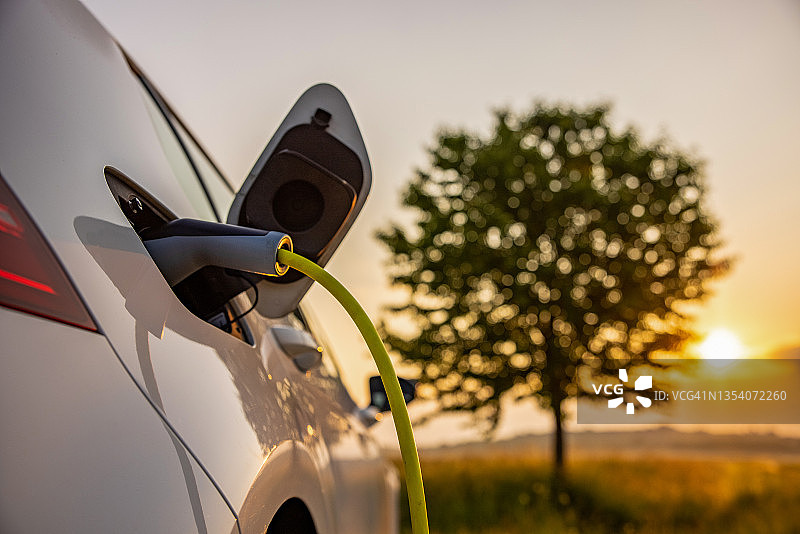 在乡村田野给电动汽车充电图片素材