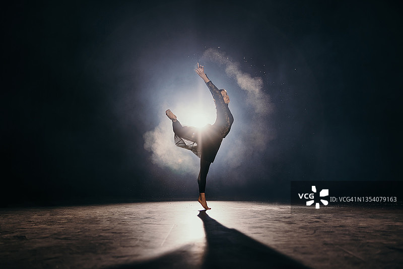 年轻芭蕾舞演员在跳舞时甩掉手中的灰尘图片素材