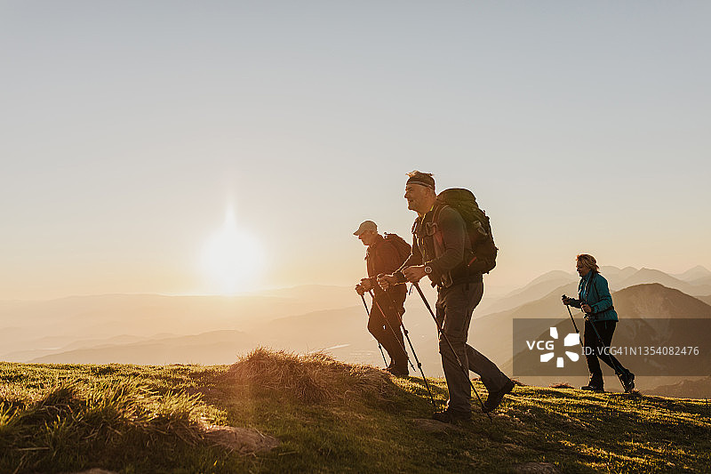 年长的男女徒步旅行者在山上行走图片素材