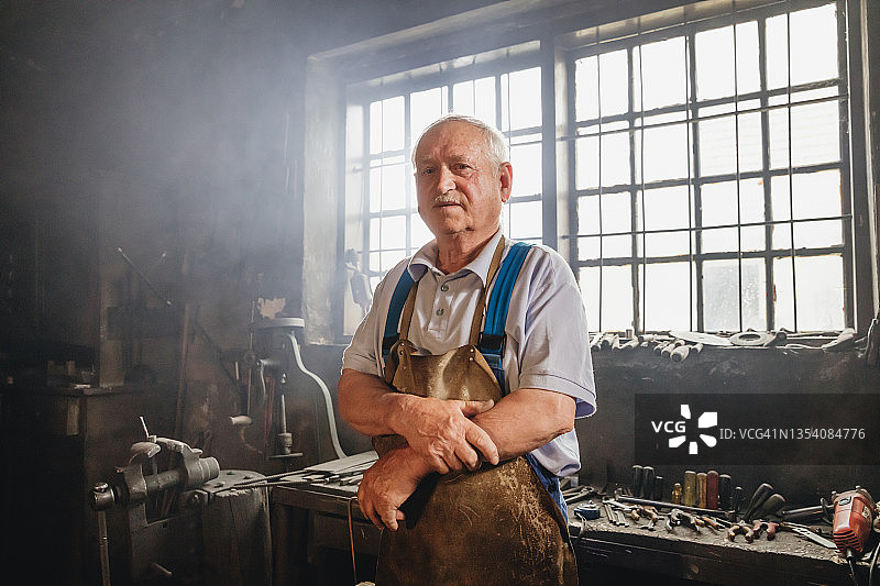 车间里一位年长的铁匠肖像图片素材