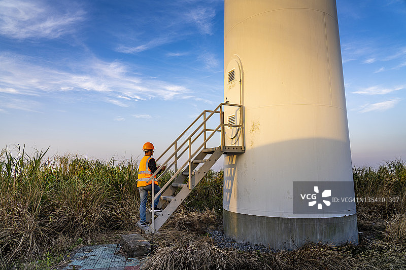年轻男工程师在日落时使用iPad，碳中和概念图片素材