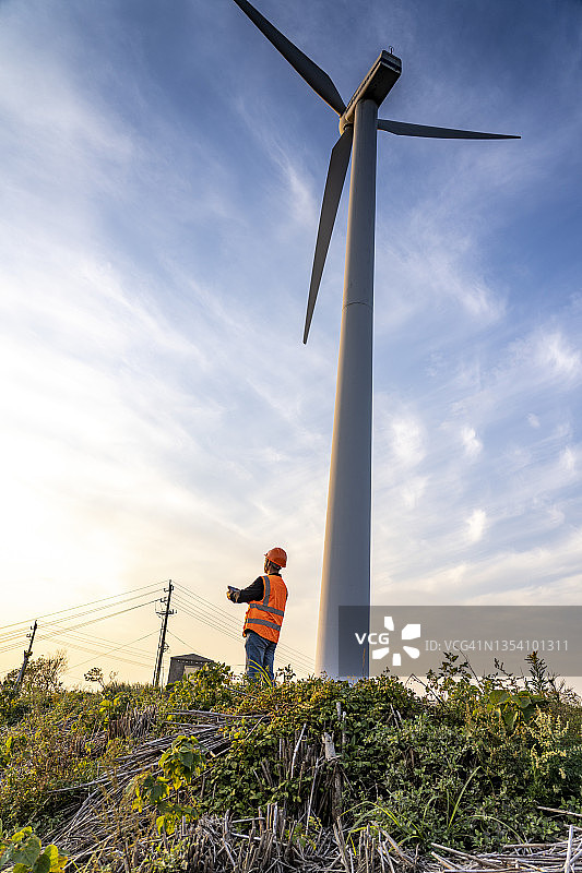 年轻男工程师在日落时使用iPad，碳中和概念图片素材