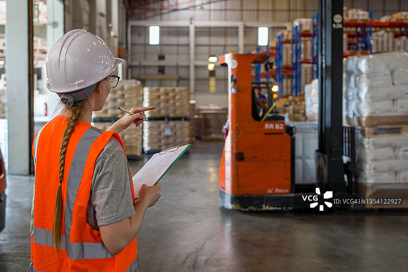 女工在大型工业工厂中检查机器图片素材