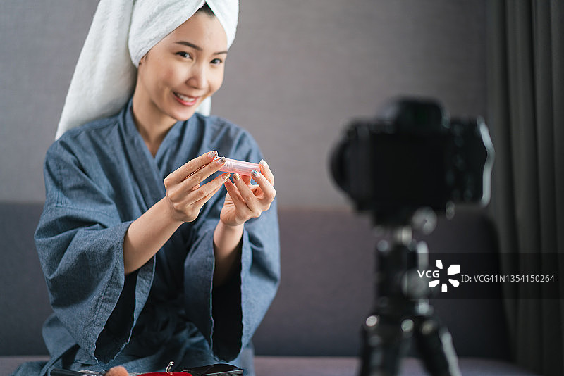 亚洲美妆博主在家直播讲解口红产品图片素材