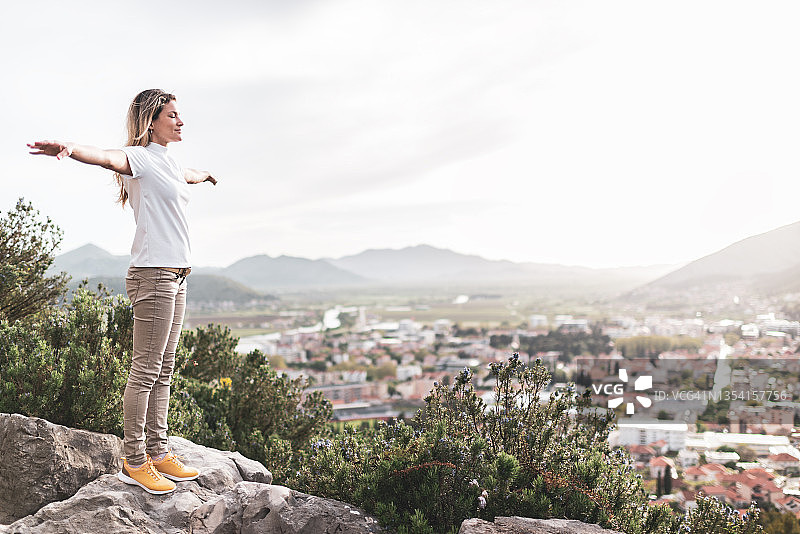 在日落时分山区做瑜伽的年轻女人图片素材