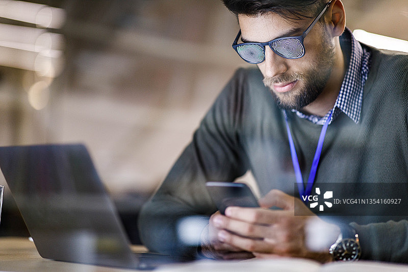 使用催眠眼镜和手机的男子图像处理图片素材