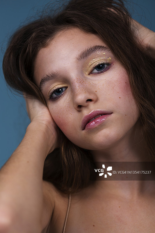 蓝色背景上的精致妆容女人特写图片素材