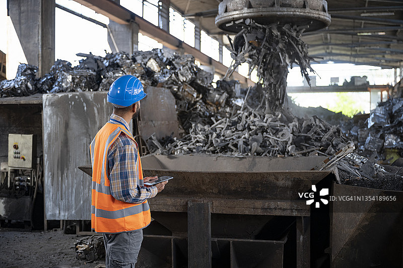 男子在回收设施监督废料磁铁图片素材
