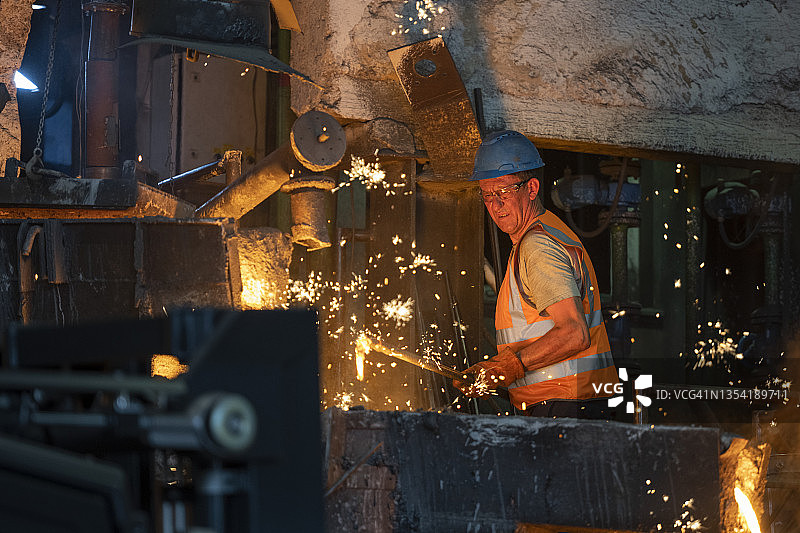 中年男人在钢铁厂检查熔融金属图片素材