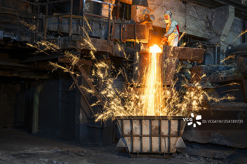 工人倾倒熔融金属时产生火花图片素材