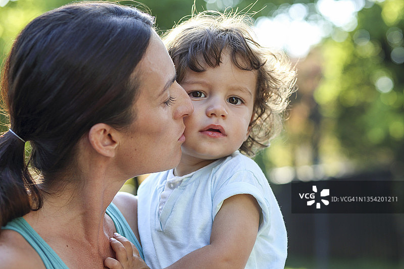 母亲亲吻她的幼儿图片素材