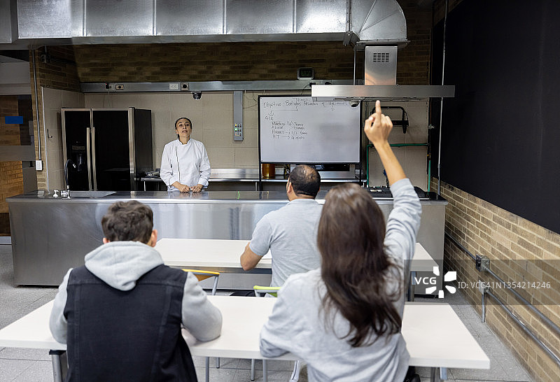 烹饪课上举手提问的女人图片素材