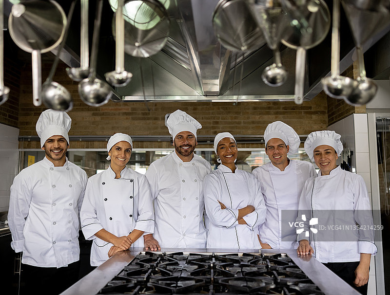 在商业厨房工作的快乐厨师们图片素材