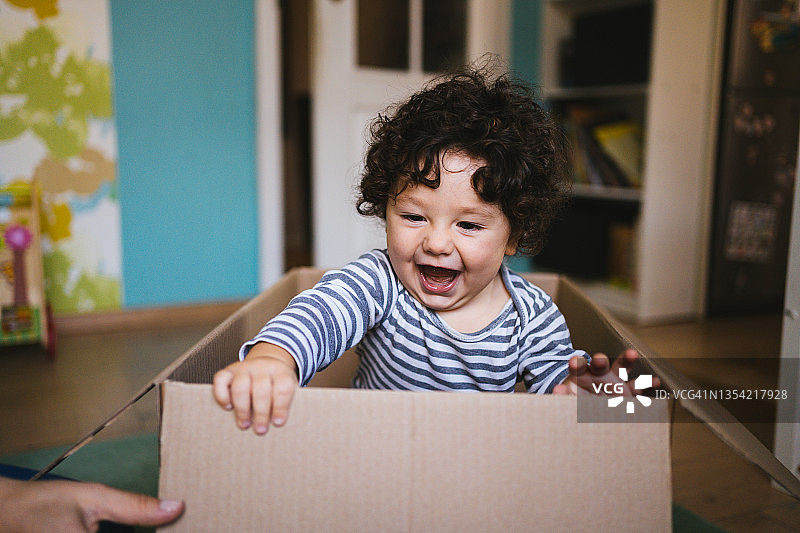 搬家期间，小男孩在纸箱里玩耍图片素材