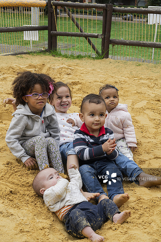 五个孩子在公园沙坑里高兴地拥抱做理疗图片素材