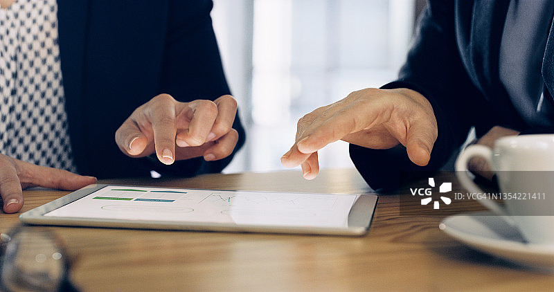 两位身份不明的商人在办公室使用平板电脑图片素材