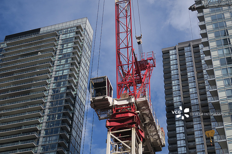 仰望住宅楼前的建筑起重机图片素材