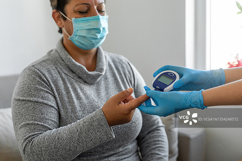 护士在家中进行血糖测试图片素材