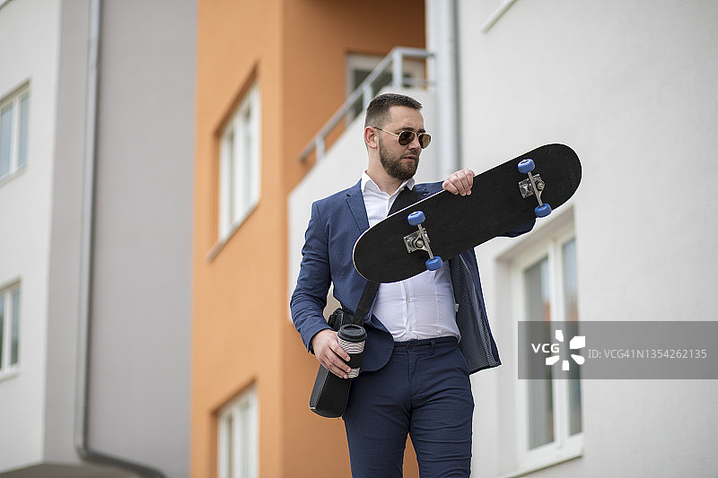 在街上踩滑板移动的商人图片素材