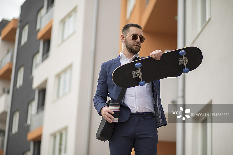 在街上踩滑板移动的商人图片素材