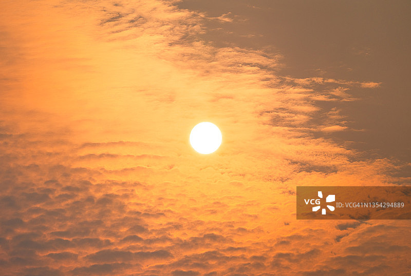 朦胧夏日清晨，阳光穿透云层升起图片素材