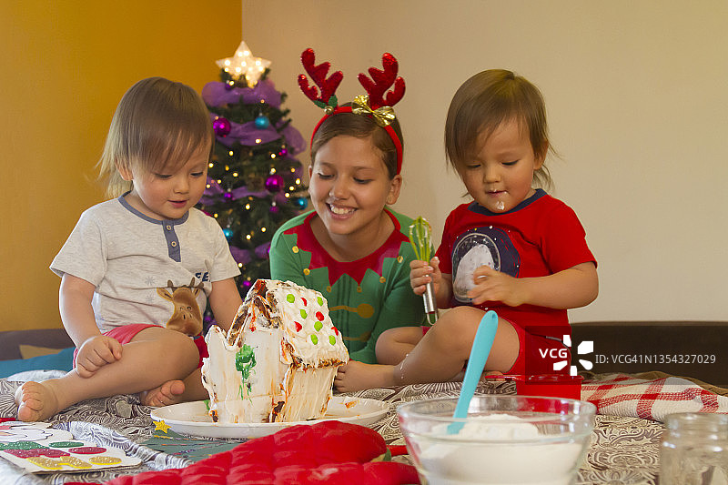 拉丁裔年轻姐弟/兄妹在拉丁美洲家中一起制作姜饼圣诞小屋的特写图片素材