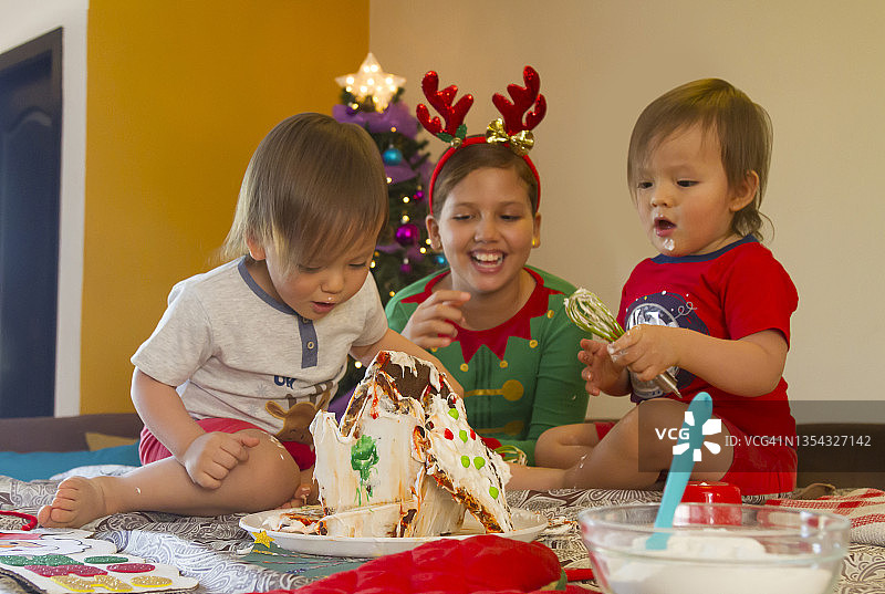 拉丁裔年轻姐弟/兄妹在拉丁美洲家中一起制作姜饼圣诞小屋的特写图片素材