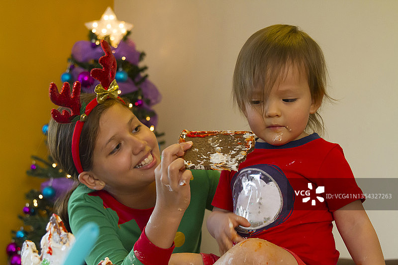 拉丁美洲家庭圣诞夜制作姜饼屋的拉丁裔小兄妹特写图片素材