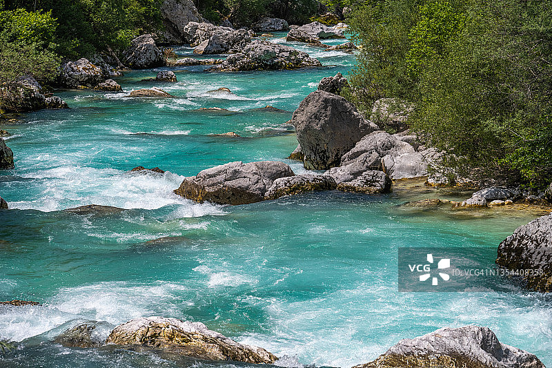 狂野山河的岩石河床，碧绿的水在急流中翻滚图片素材