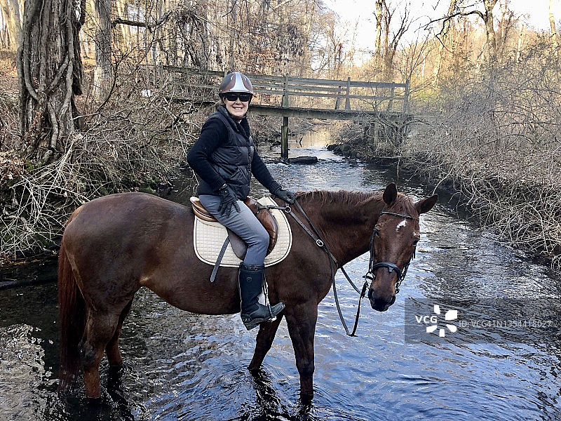 女人骑在马背上，在河中图片素材