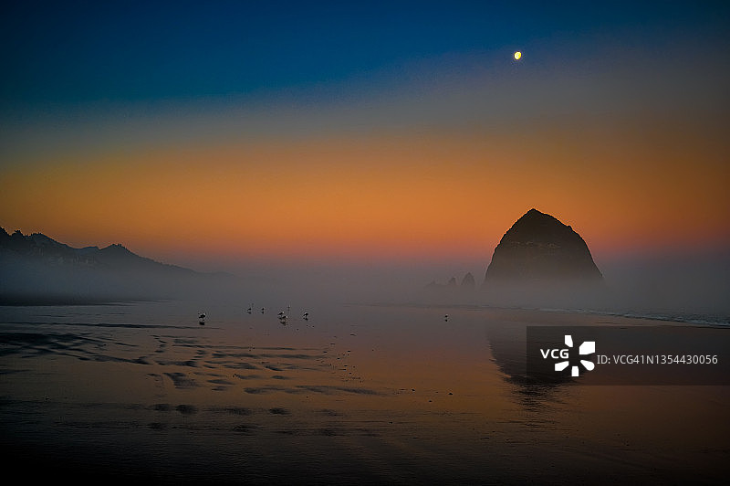 俄勒冈州炮台海滩干草堆岩上空的黎明月色图片素材