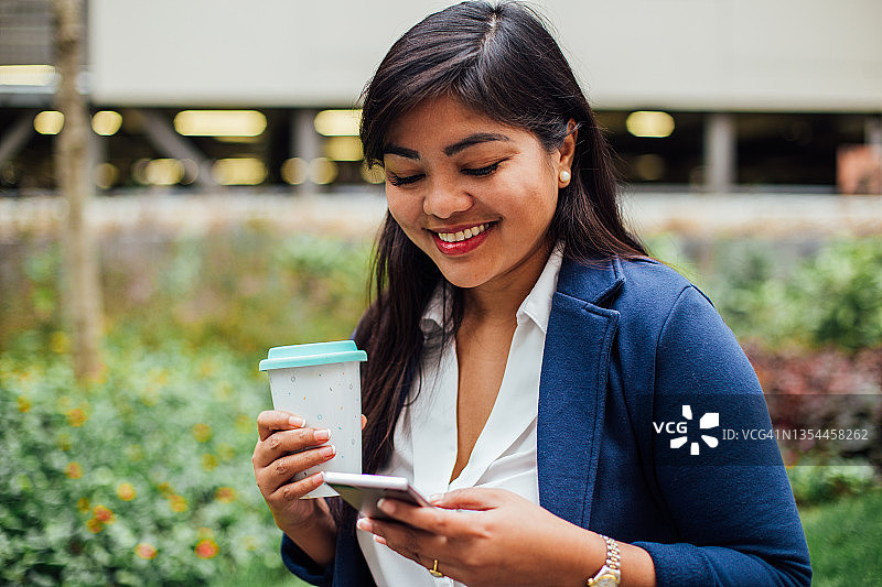 在户外享受咖啡的可爱亚洲女人画像图片素材
