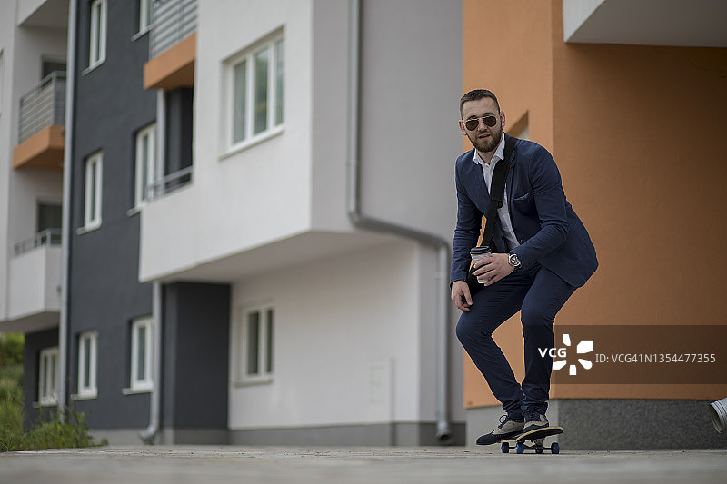 在街上踩滑板移动的商人图片素材