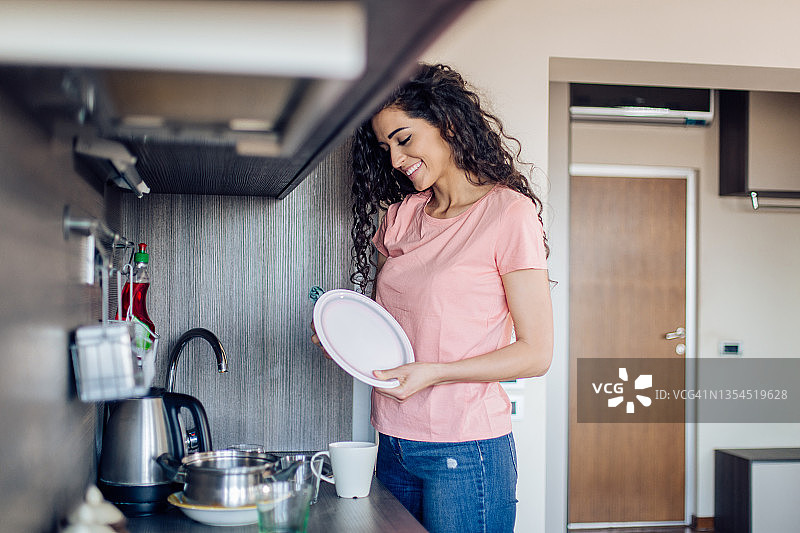 快乐的女人在厨房洗碗图片素材