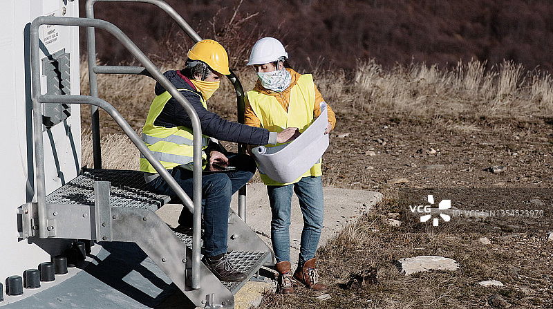 在COVID-19期间在风电场工作的风能工程师。可再生能源系统。碳中和与可持续能源。图片素材