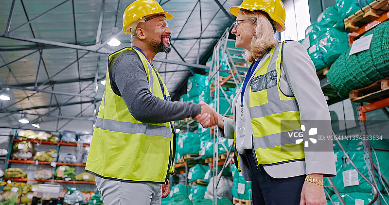 仰视角度拍摄的中年男人和女人在仓库里握手图片素材