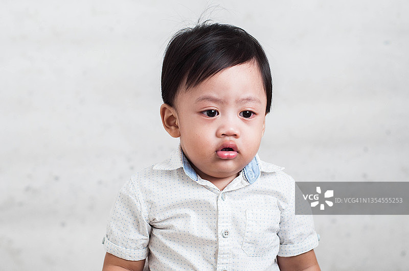 白色背景下严肃的东南亚男婴肖像图片素材